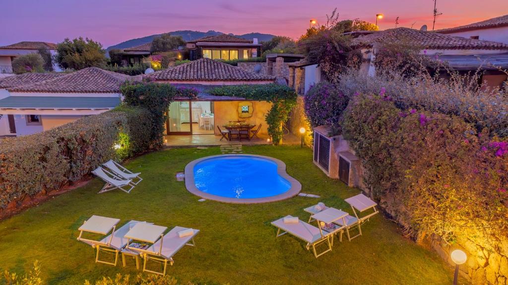 a backyard with a pool and chairs and a house at CASA MAESTRALE 6, Emma Villas in Palau