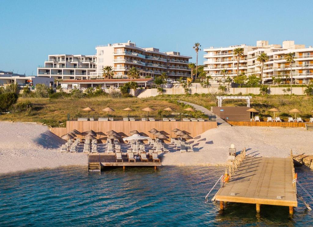 Casa De Playa Luxury Hotel & Beach في إزمير: رصيف به كراسي ومظلات على الشاطئ