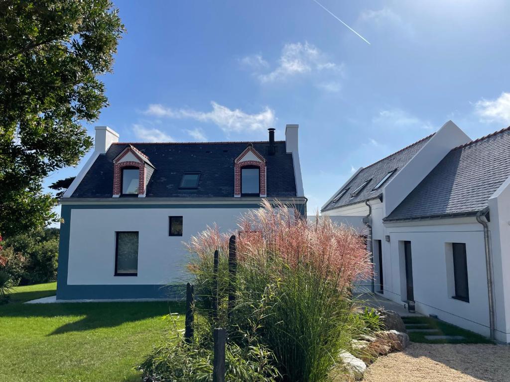 una casa blanca con techo negro en Chambres d'Hôtes B&B Roz Rozenn en Sauzon