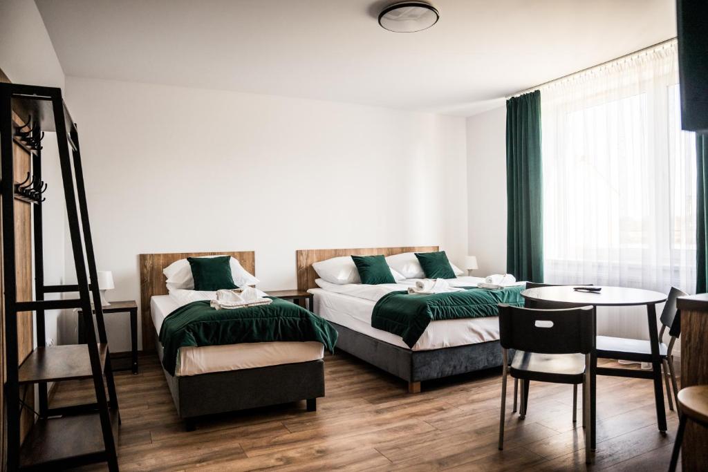 - une chambre avec 2 lits, une table et des chaises dans l'établissement Apartamenty W Centrum Chrzanowa, à Chrzanów