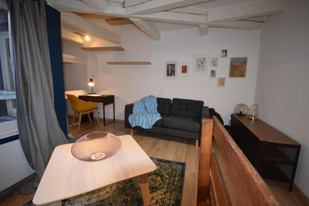 un salon avec un canapé et une table dans l'établissement Le Studio du Quai des Pêcheurs - Charmant duplex sur les quais, à Strasbourg