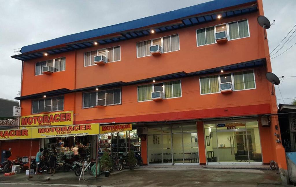 an orange building with a store with bikes parked outside at RedDoorz @ Johsons Pension House Butuan City in Butuan