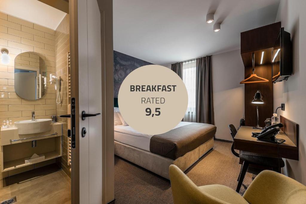 um quarto de hotel com uma cama e um lavatório em Hotel Mrak Superior em Liubliana