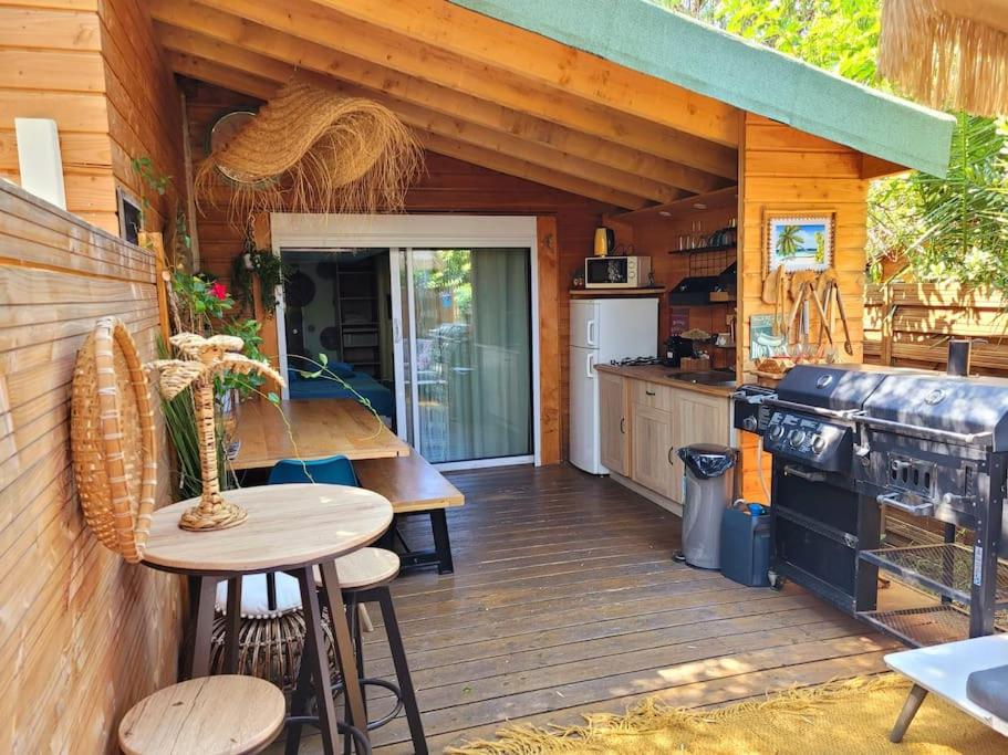 a kitchen with a wooden deck with a table and a stove at Petit chalet " L' Oiseau de Paradis " in Fréjus