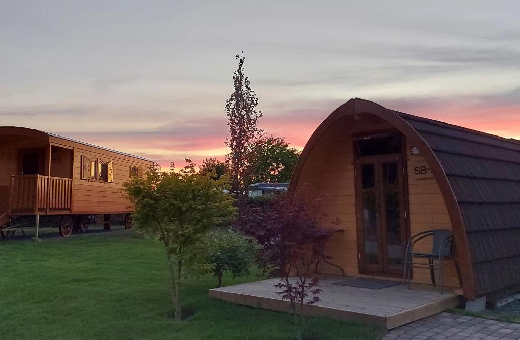 ein winziges Haus und ein Wohnwagen in einem Hof in der Unterkunft Ferienpark Auf dem Simpel - Schnuckenbude 2 in Soltau