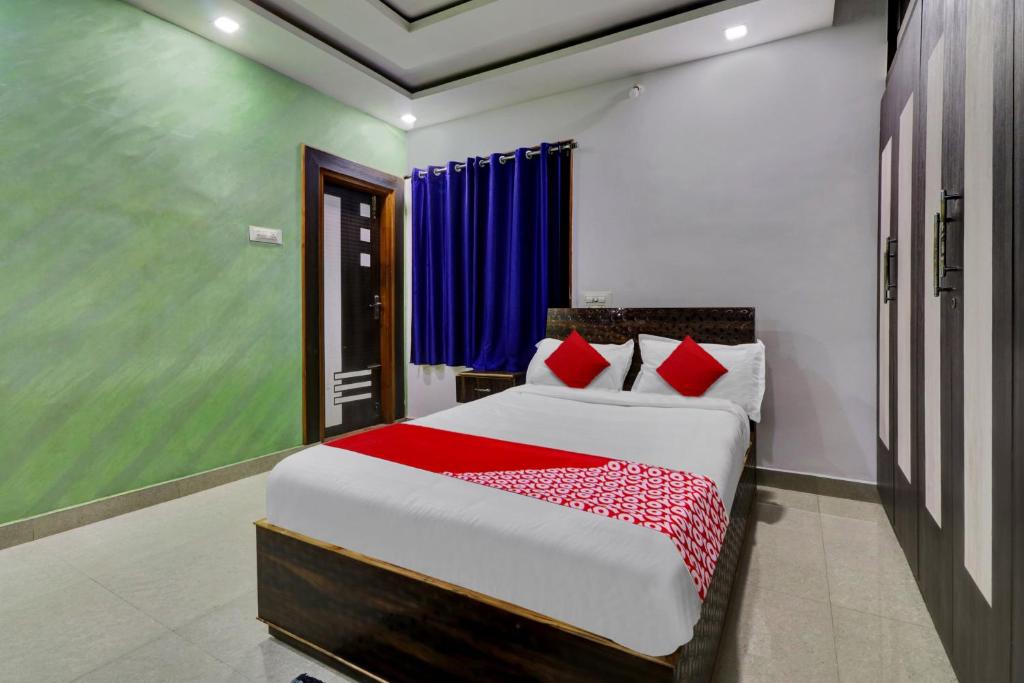 a bedroom with a large bed with red pillows at Hotel O SESHADRI HOMESTAY in Tirupati