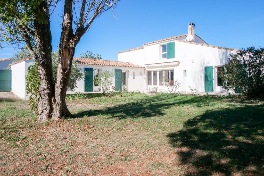 uma casa branca com uma árvore no quintal em Echappee insulaire tout pres de la plage em Sainte-Marie-de-Ré