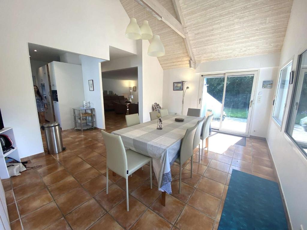 une salle à manger avec une table et des chaises blanches dans l'établissement Maison pour grande famille avec jardin, terrasse, proche Golf et Port à La Forêt-Fouesnant - FR-1-481-149, à La Forêt-Fouesnant