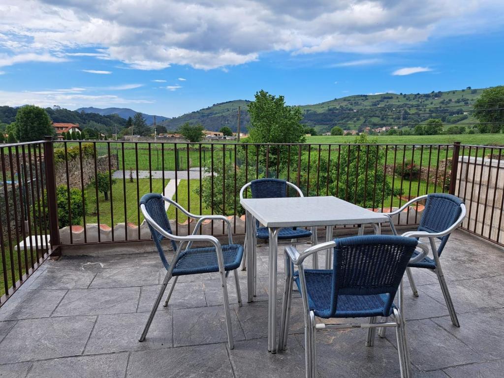 a table and chairs on a patio with mountains in the background at alojamiento el árbol rojo in Selaya