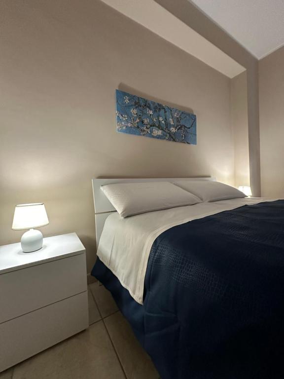 ein Schlafzimmer mit einem Bett und einer Lampe auf einem Nachttisch in der Unterkunft Le radici dell’Etna holiday house in Paterno
