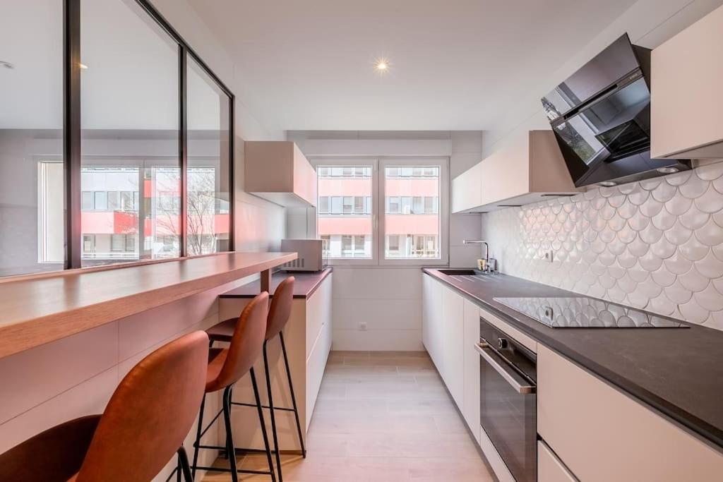 - une cuisine avec un comptoir et quelques chaises dans l'établissement Plume - Joli appt refait à neuf, à Strasbourg