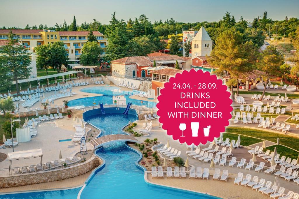 d'une piscine avec des chaises et un panneau. dans l'établissement Residence Garden Istra Plava Laguna, à Umag