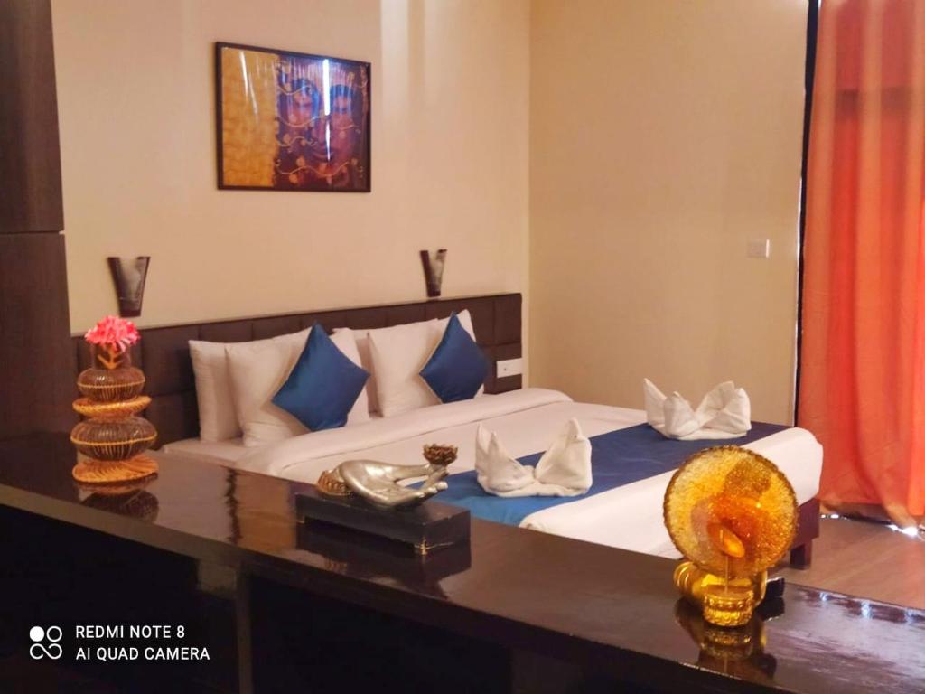 1 dormitorio con 1 cama con almohadas azules y blancas en Staynest gangtok 300 mtr from MALL ROAD en Gangtok