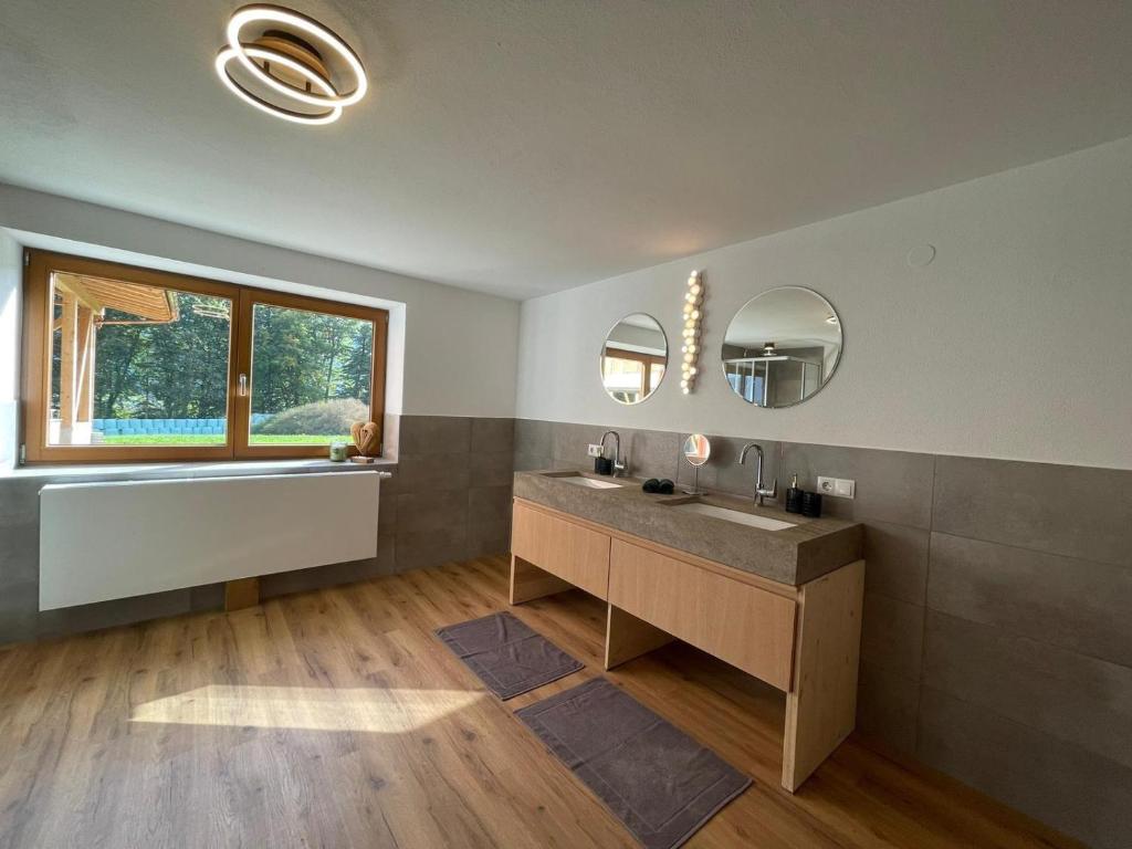 baño con lavabo y 2 espejos en Untergrübelhof, en Breitenbach am Inn