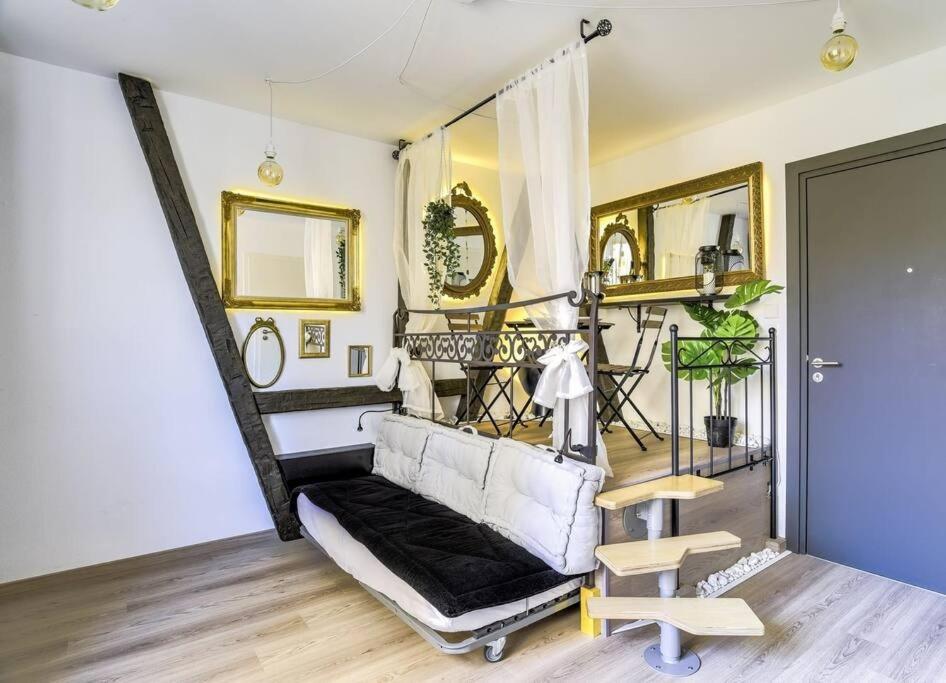 - un salon avec un canapé blanc et des miroirs dans l'établissement L'Entracte Strasbourgeoise - Charmant studio au cœur de la Petite France, à Strasbourg