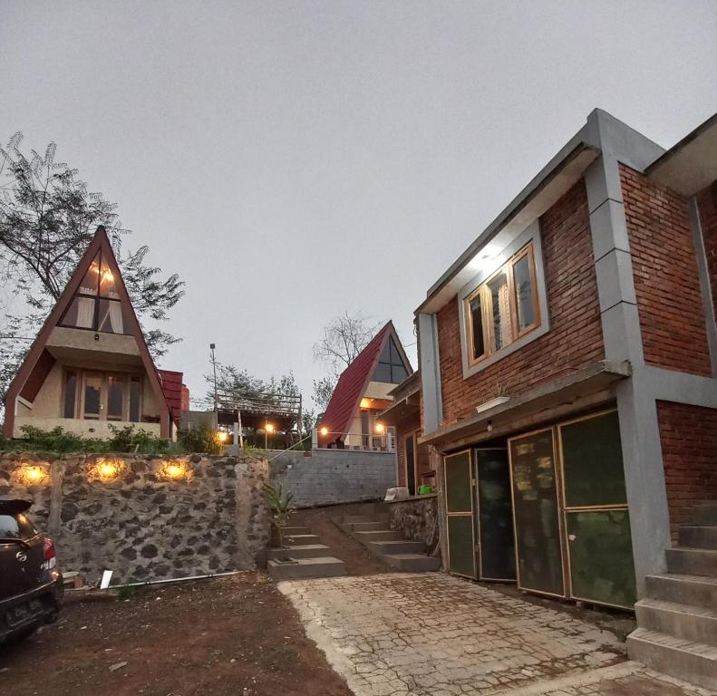 a house with a stone wall and a garage at Agora Home in Wonosobo