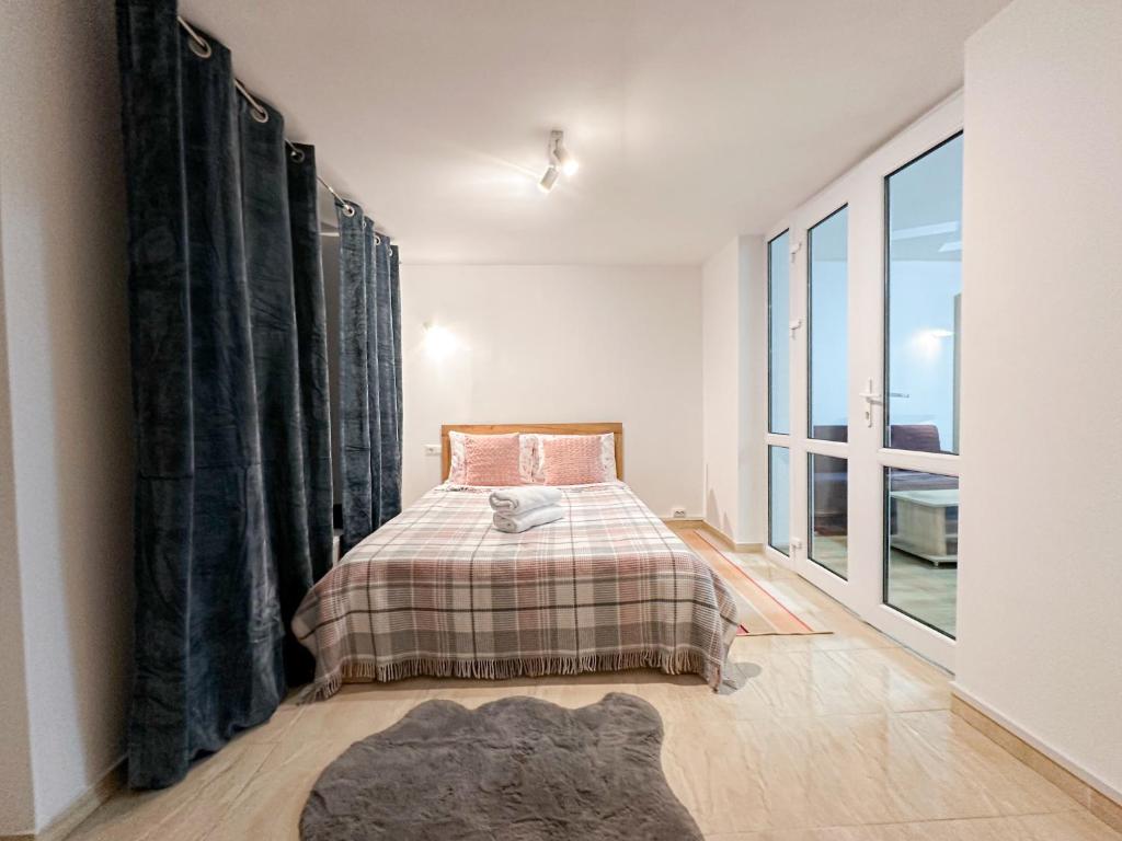 a bedroom with a bed and a large window at Renthouse Apartments City Gates #5 in Chişinău