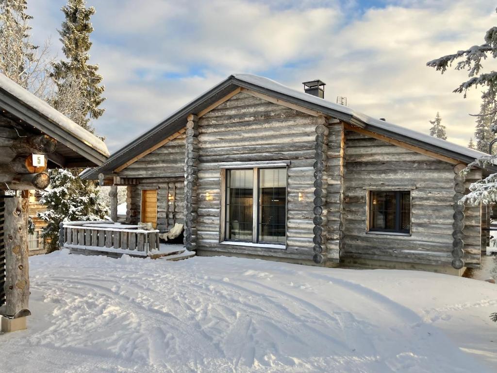 a log cabin in the snow with a driveway at VILLA TUNDRA in Ruka