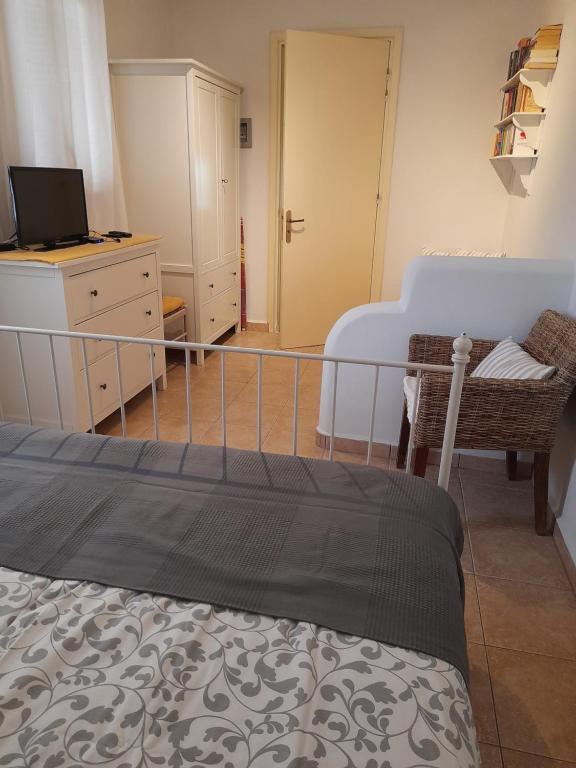 a bedroom with a bed and a desk with a television at Aperi View in Karpathos