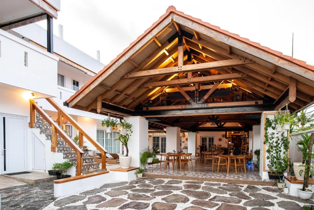 an outdoor patio with a wooden roof and tables at Keramas Moonlight Villa in Keramas