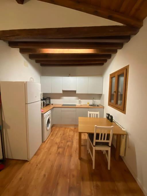 Una cocina con una mesa y un refrigerador blanco. en Gigantones, en Toledo