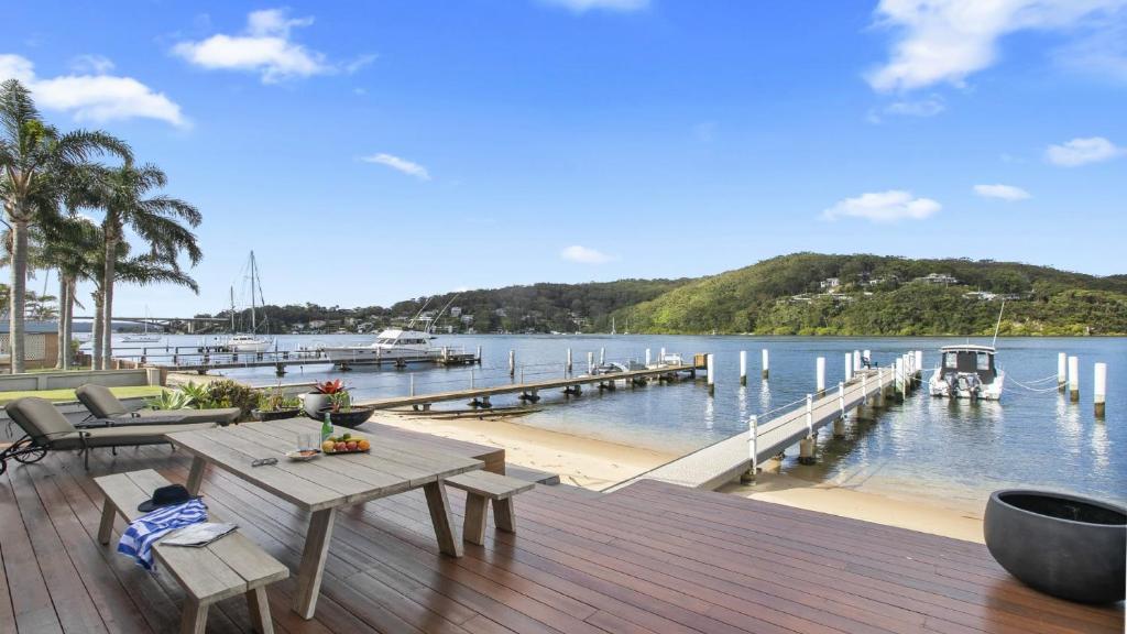 a wooden deck with a table and a dock at Riptides Booker Bay -Pay 2, Stay 3 nights this WINTER in Booker Bay