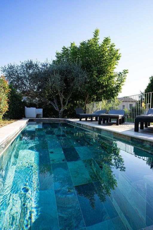 - une piscine d'eau bleue et deux bancs dans l'établissement Villa Cocoon Lourmarin, à Lourmarin