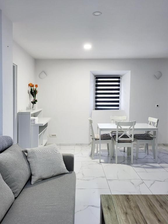 a living room with a couch and a table and chairs at Stara Pošta Apartment 1 in Grosuplje