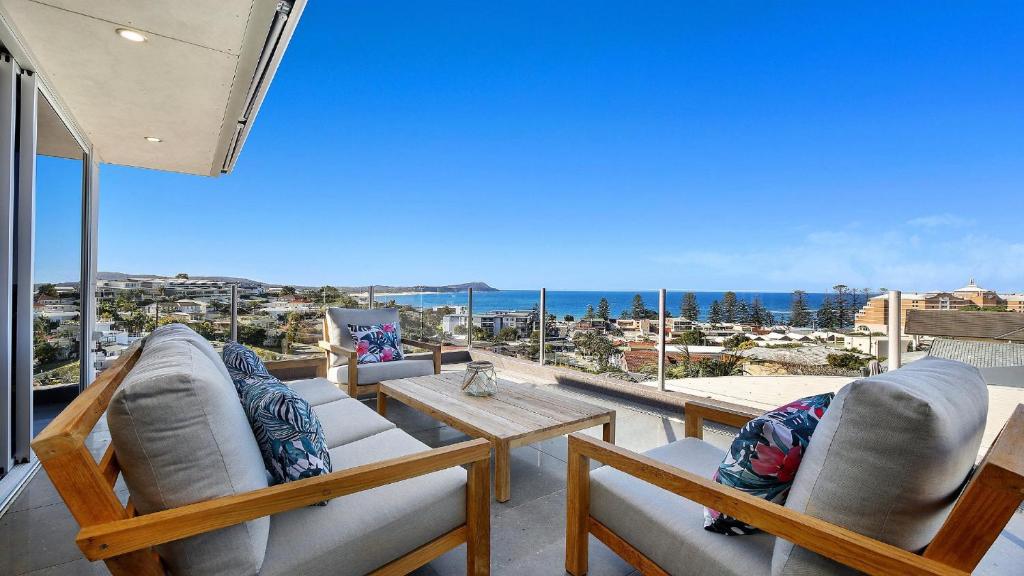 a balcony with chairs and a table and a view of the ocean at Amazing Views and Short Walk To Beach in Terrigal