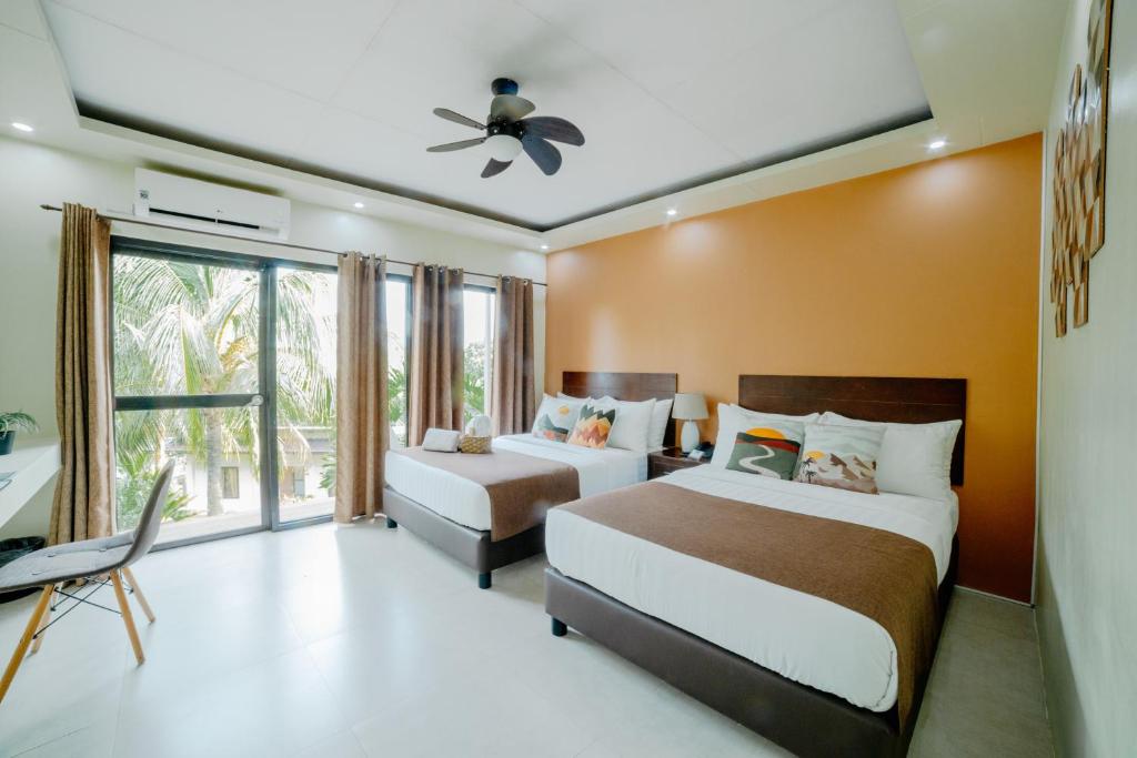 a bedroom with two beds and a ceiling fan at Spacio Caliraya Bed & Breakfast in Lumban