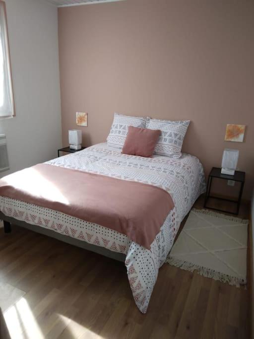 a bedroom with a large bed with two night stands at Appartement Cosy avec Terrasse in Vaux-sur-Seine