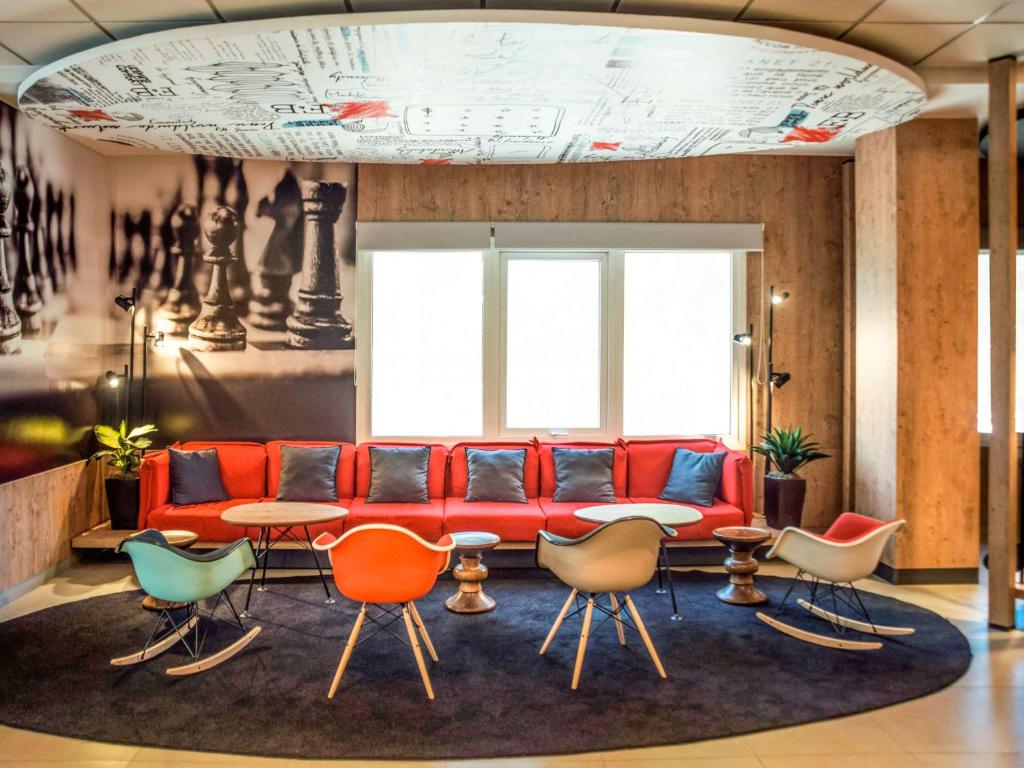 a living room with a red couch and chairs at ibis Asuncion in Asunción