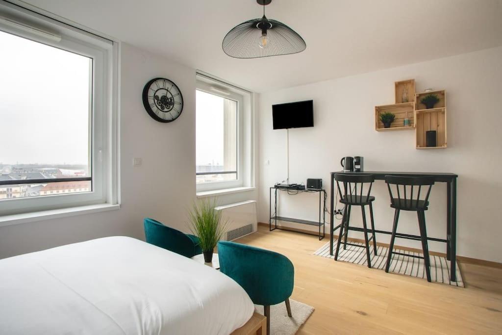 - une chambre avec un lit, des chaises et une horloge dans l'établissement A L'Horizon - Joli Studio dans Strasbourg, à Strasbourg