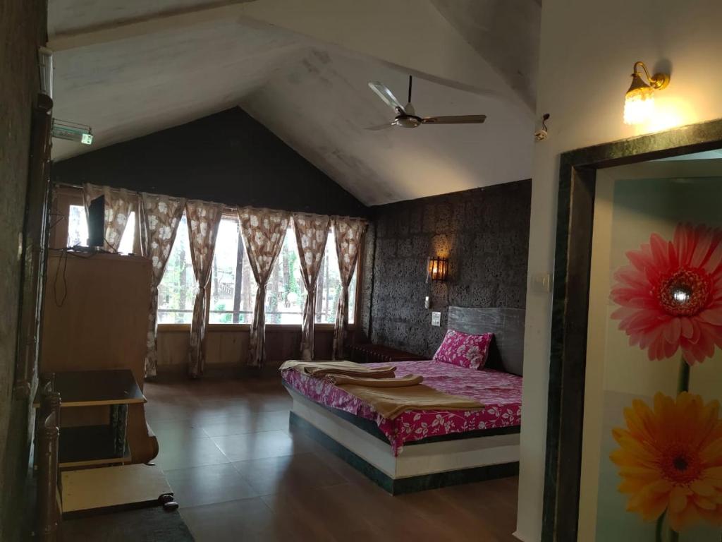 Vamoose Manali Beach Resort في Bhogwe: غرفة نوم مع سرير وملاءات وردية ونافذة