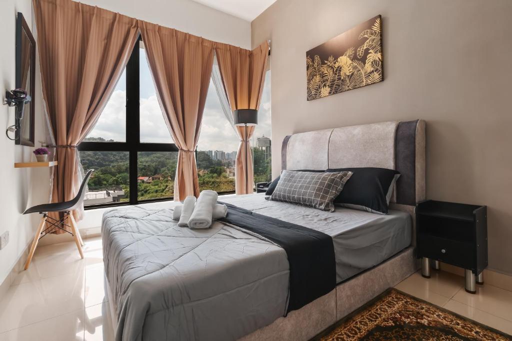 um quarto com uma cama e uma grande janela em Gombak Homestay at Ayuman Suites Kuala Lumpur em Kampong Kerdas