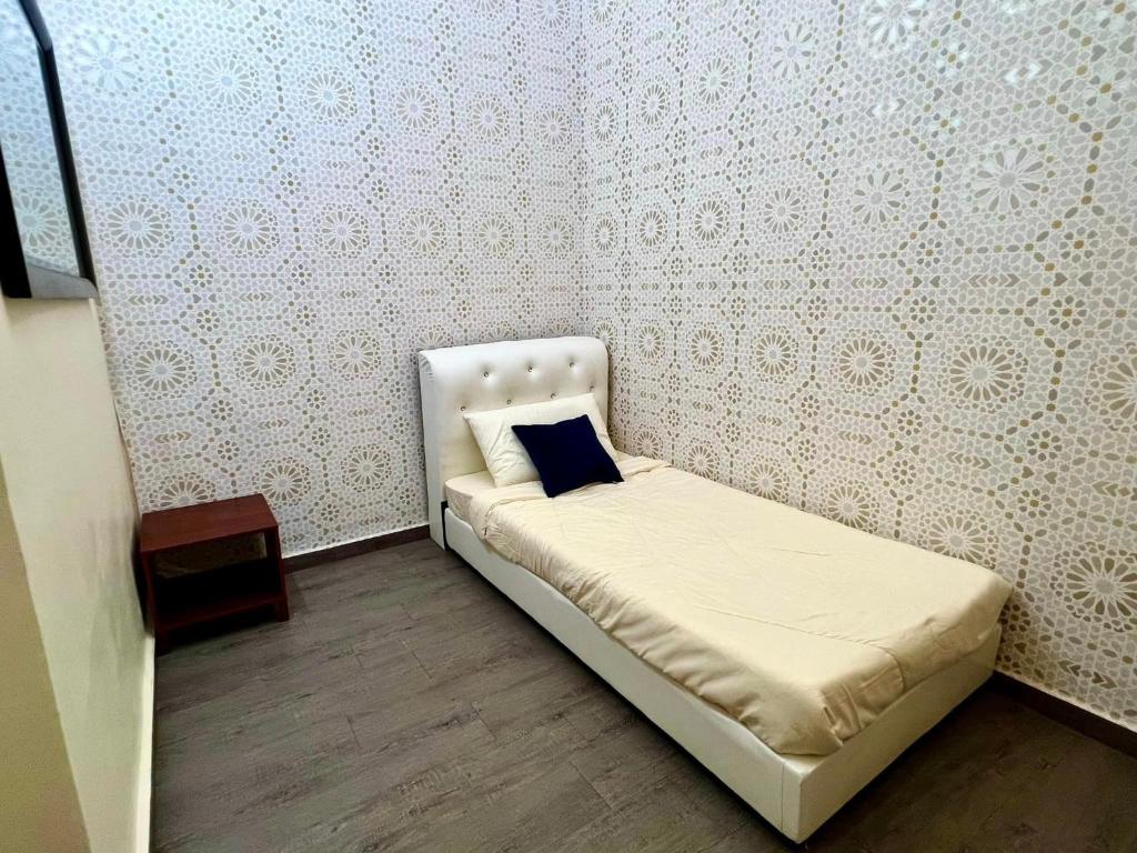 Dormitorio pequeño con cama con almohada azul en Rumah Mok Aji Homestay Melaka en Melaka