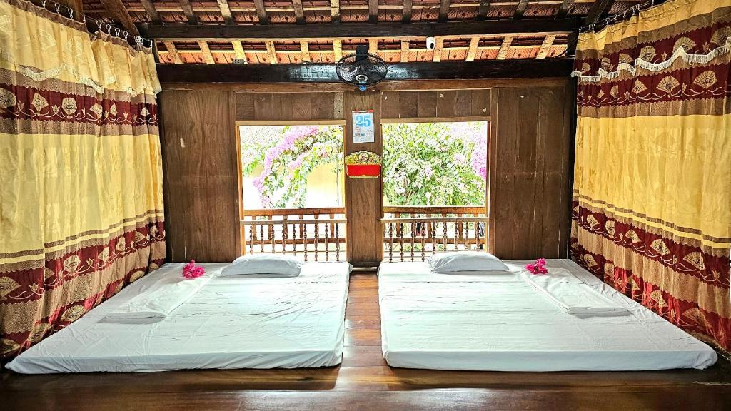 Duas camas num quarto com uma janela em Homestay Chung Thúy em Ha Giang