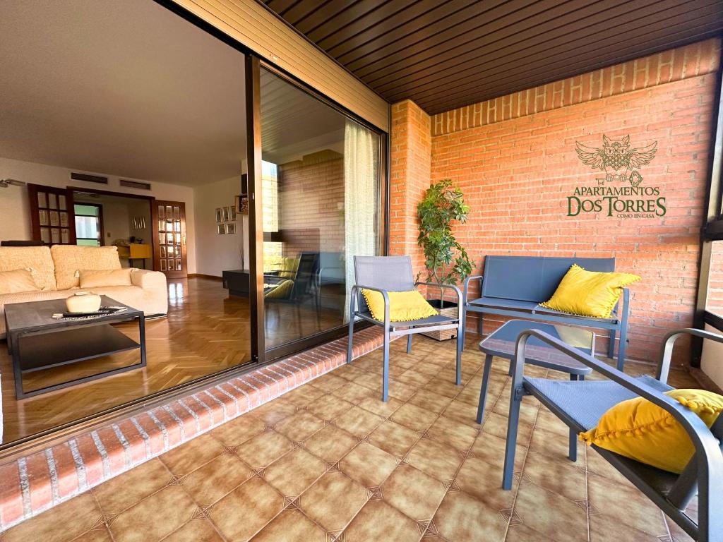 a patio with chairs and tables and a living room at Dos Torres Gómez Laguna - Estacionamiento Privado Gratuito in Zaragoza