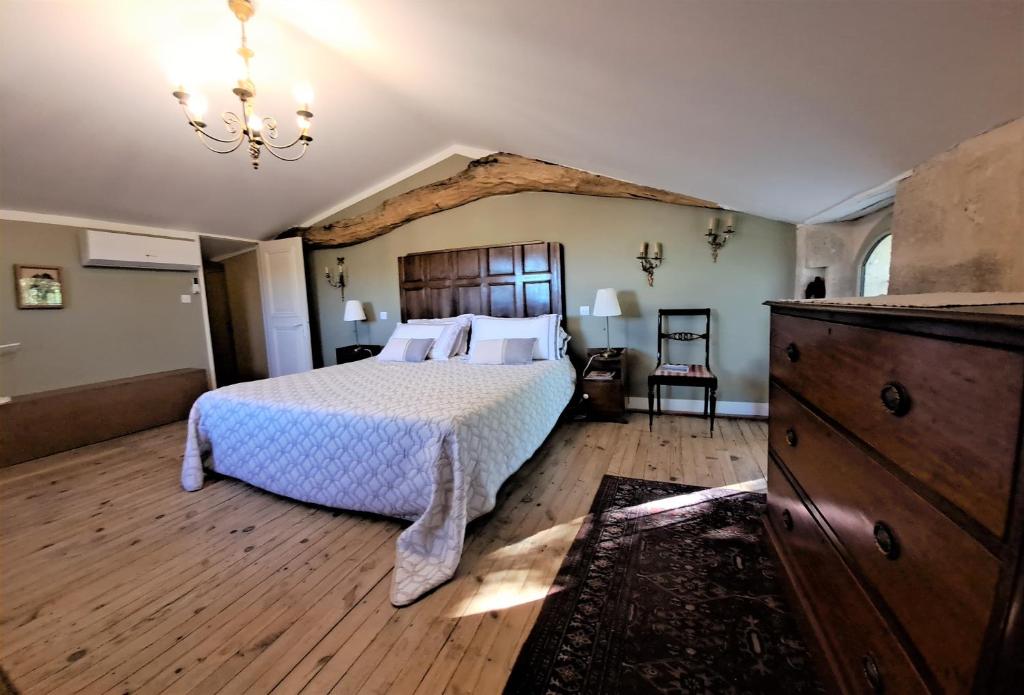 a bedroom with a large bed and a dresser at La Chartreuse d'Ertan "Les vignerons" 4 étoiles in Saint-Christophe-des-Bardes