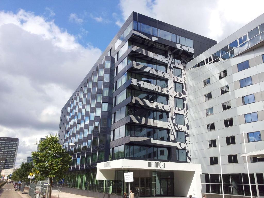 a tall building with a sign on the side of it at Mainport Hotel Rotterdam, a Hilton Affiliate Hotel in Rotterdam