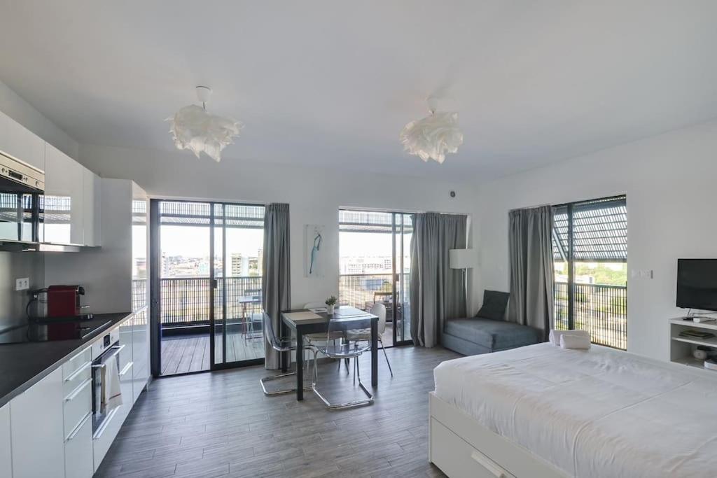 une chambre avec un lit et une table et une cuisine dans l'établissement Bassin d'Austerlitz - Studio avec terrasse dans l'une des tours Black Swans, à Strasbourg