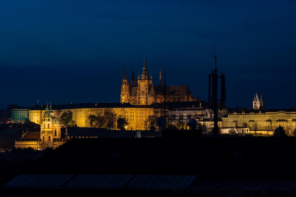 a lit up city at night with a castle at Castle View Apartment in Prague