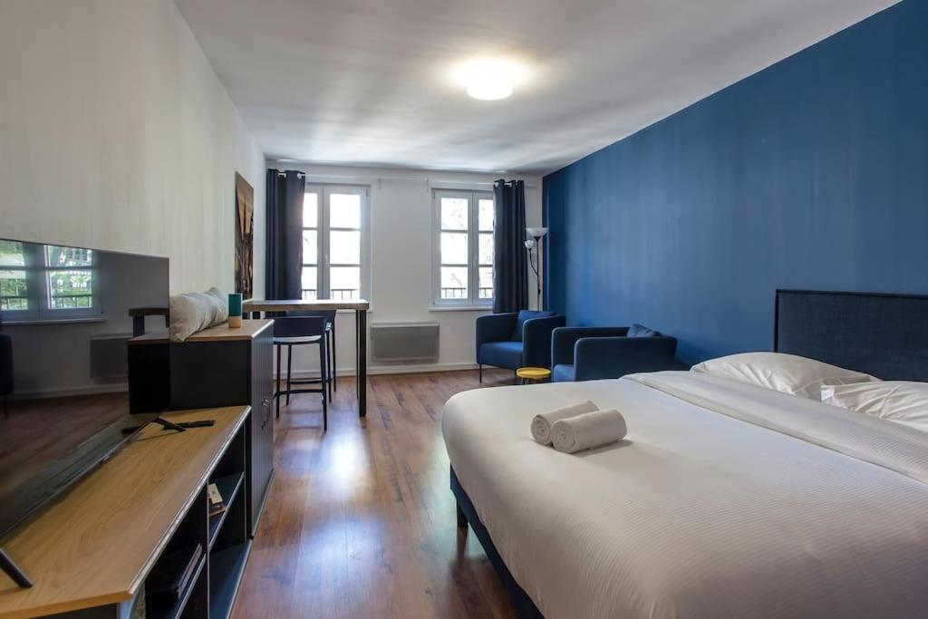 une chambre avec un lit et un mur bleu dans l'établissement Le 52 Zix - Joli studio au cœur de la Petite France, à Strasbourg