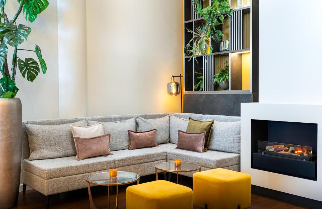 a living room with a couch and a fireplace at Leonardo Hotel Salzburg Airport in Salzburg