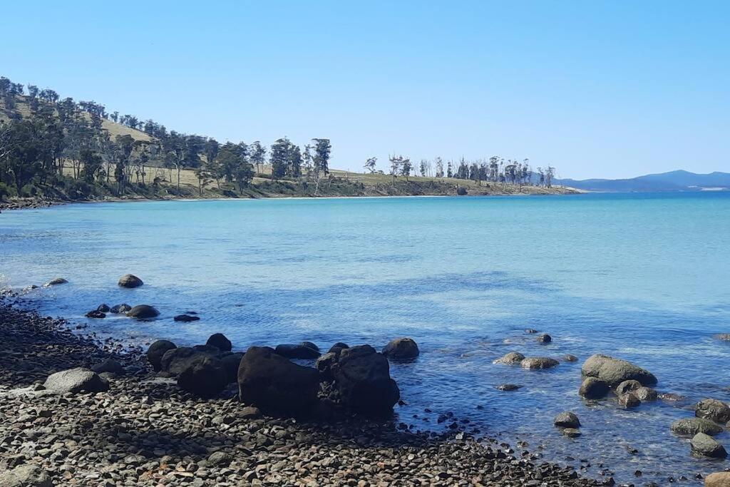 een grote hoeveelheid water met rotsen aan de kust bij Evergreen Cabin in Primrose Sands
