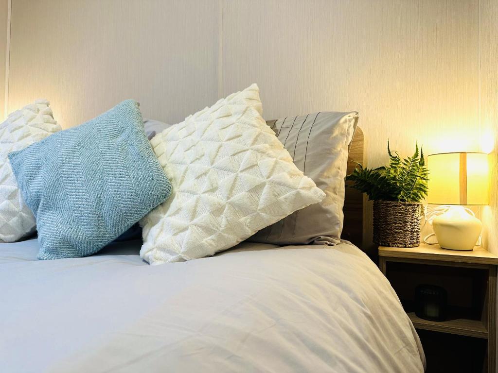 a bed with four pillows on top of it at Beach Grove in Scarborough