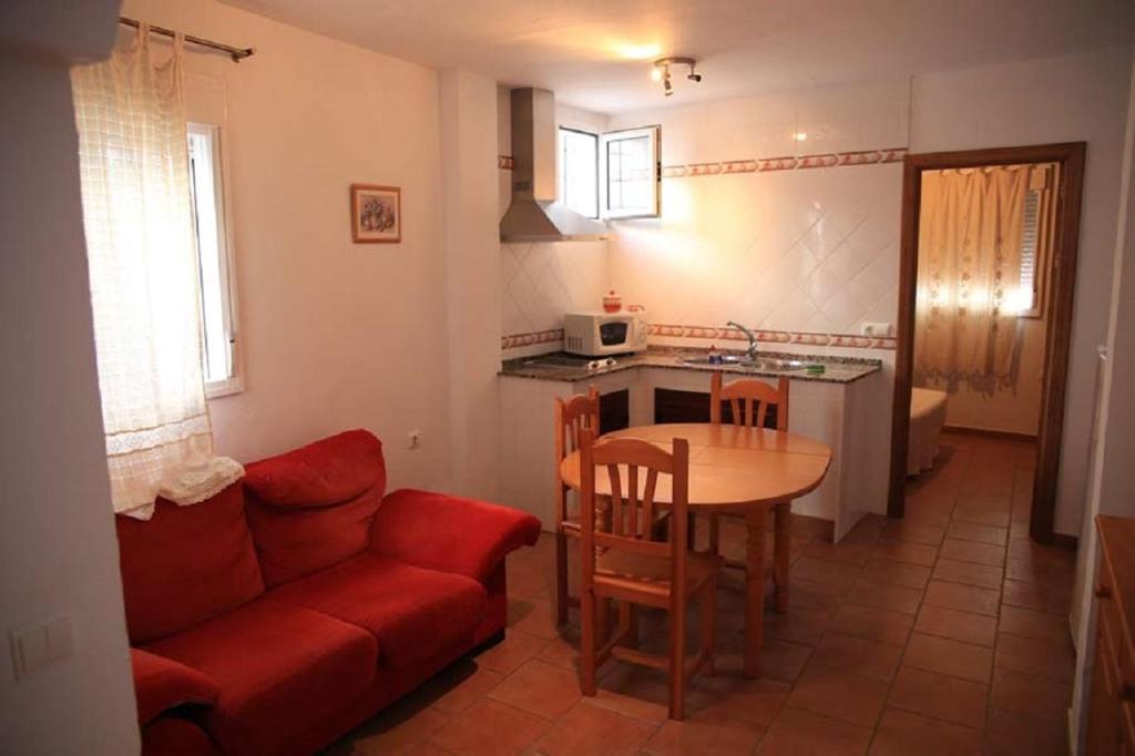 sala de estar con sofá rojo y mesa en Apartamento Cadiz Bajo, en Conil de la Frontera