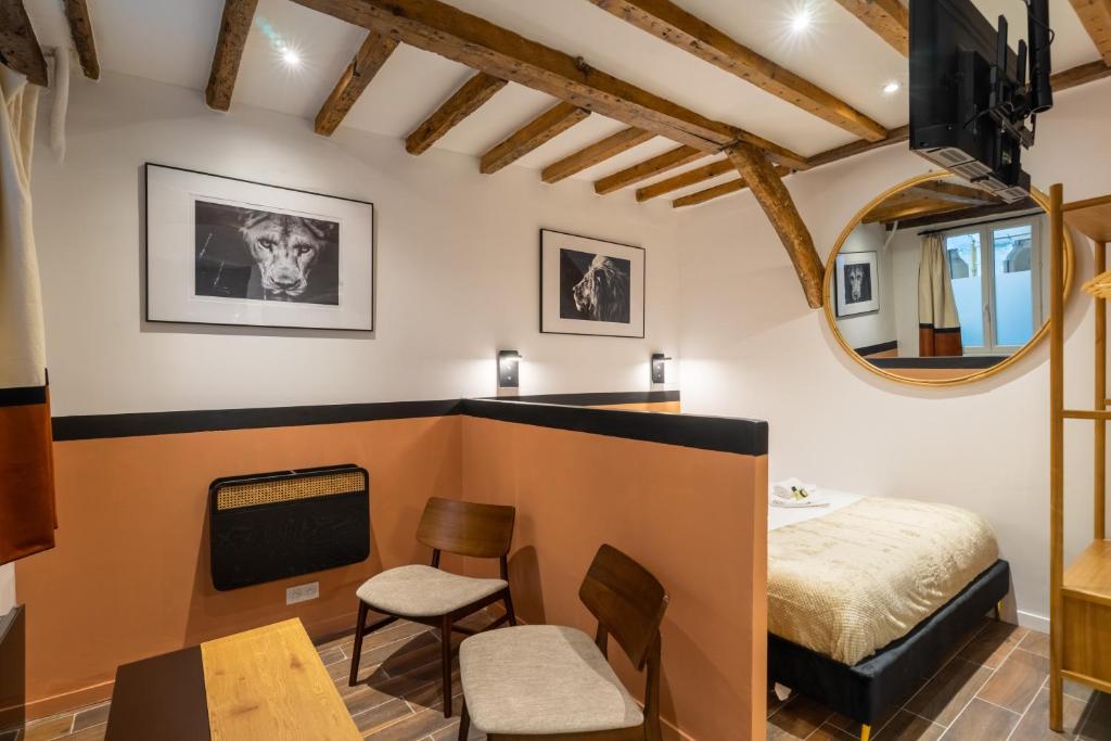 une chambre avec un lit, une table et des chaises dans l'établissement Luxe Marais Getaway - Suite Exclusive avec Sauna, à Paris
