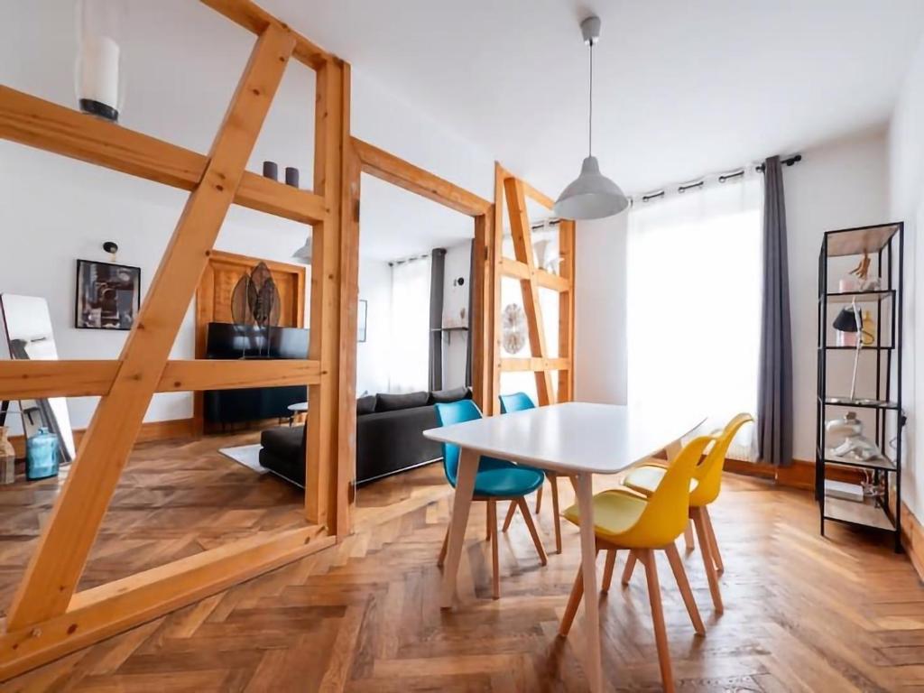 6 Rue de Zurich - T3 avec grande terrasse في ستراسبورغ: غرفة طعام وغرفة معيشة مع طاولة وكراسي