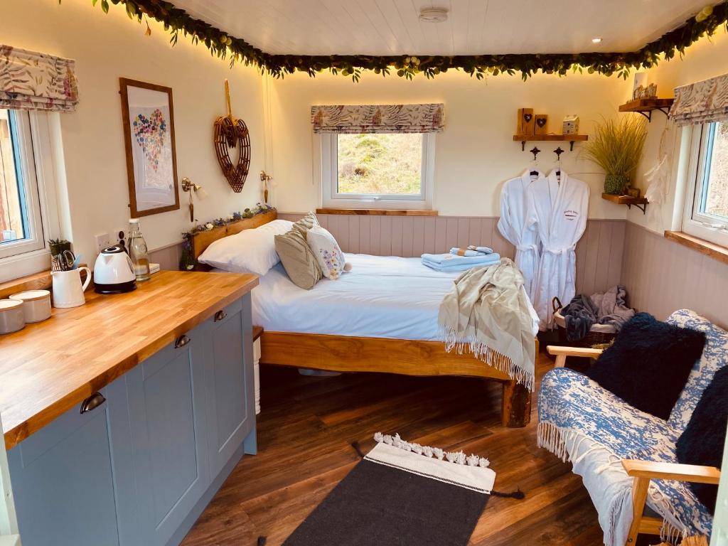 a bedroom with a bed and a chair in it at The original Sleeping Giant Lodge - Farm Stay, meet the animals in Ystradgynlais